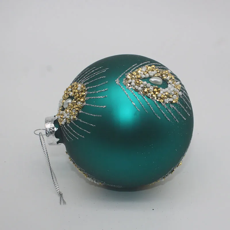 This teal blue Christmas ornament features a delicate hand-painted design with gold and white decorations.