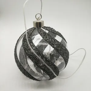 This product is made of glass, with a glitter and ribbon design. It is battery operated and has an LED light inside.