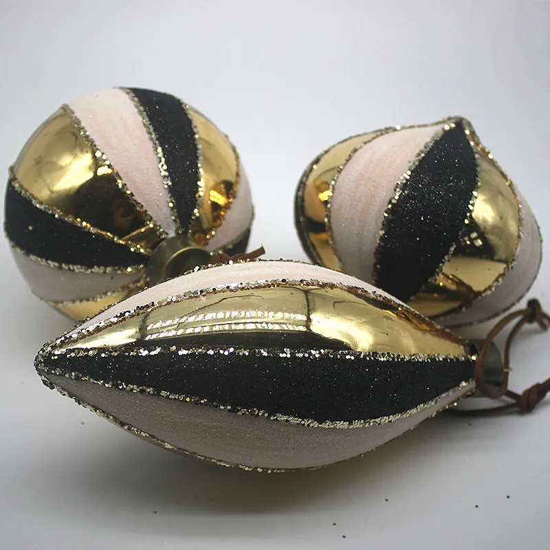 Black and gold striped glass Christmas ornaments with glitter details for festive holiday decoration.