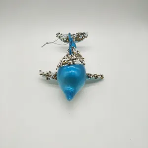 This product is a glass Christmas ornament in the shape of a whale. It is decorated with blue and gold paint and has a sparkling finish.
