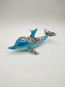This product is a beautiful blue glass blown ornament shaped like a whale. Its bright blue color, accented by shimmering gold and white beads, adds a touch of elegance to any Christmas decor.