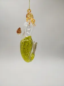 These mermaid ornaments are handmade of glass and feature a glitter finish. The mermaid is blown and molded in separate pieces, then attached to a hanging loop.