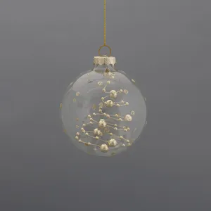 Clear glass Christmas tree ornament with gold beads, perfect for decorating your home for the holidays.