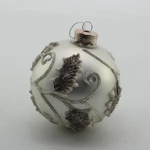 This product is a classic Christmas tree ornament with a delicate, elegant design.  It features a silver glass ball with a  leaf pattern, and it's perfect for adding a touch of sophistication to your holiday decor.