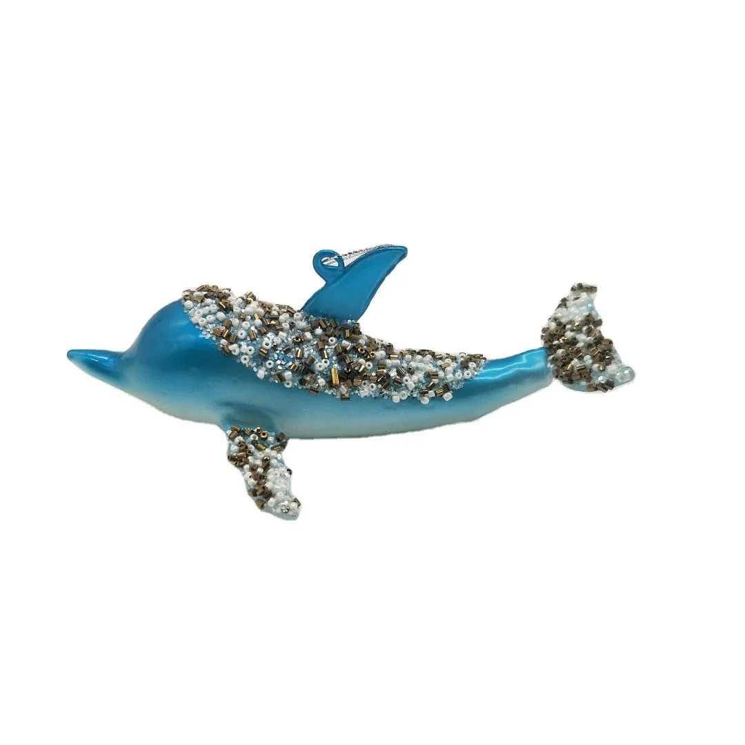 This product is a glass whale ornament with a unique and festive design. It is hand-painted with blue and gold paint and is embellished with sparkling beads.