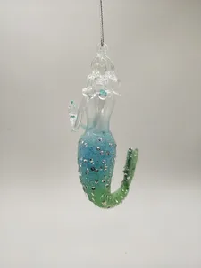 This glass mermaid ornament features a beautiful light blue to green ombre effect. The glitter adds a touch of sparkle to this unique ornament.