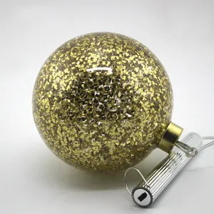 This product is a beautiful and festive Christmas ornament made of clear glass with gold glitter inside. It's perfect for adding a touch of sparkle to your holiday decor and can be used for both home and commercial use.