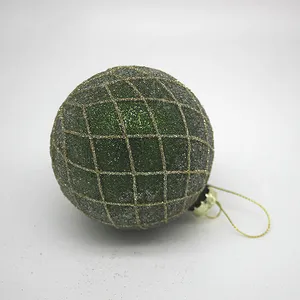 This product is a Christmas ornament ball with a green glitter finish and a gold lattice design that is applied using a delicate and intricate process.