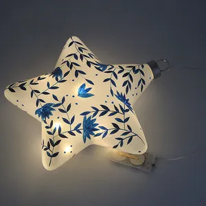 This product is made of blown glass, which gives it a unique and intricate shape. The product is then carefully hand-painted with a delicate blue floral pattern, adding a touch of artistry and craftsmanship. Each piece is carefully hand-blown and hand-painted to create a one-of-a-kind ornament.