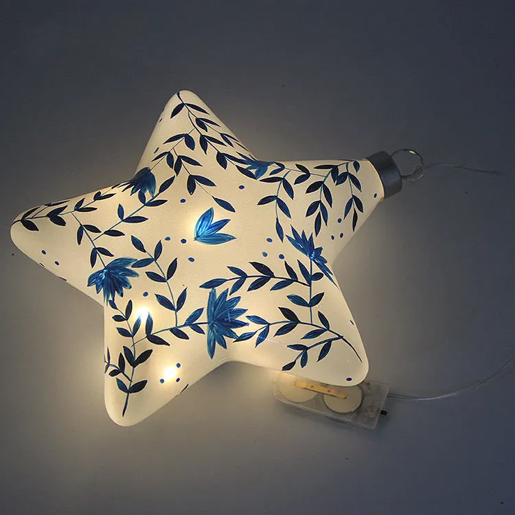 This product is made of blown glass, which gives it a unique and intricate shape. The product is then carefully hand-painted with a delicate blue floral pattern, adding a touch of artistry and craftsmanship. Each piece is carefully hand-blown and hand-painted to create a one-of-a-kind ornament.