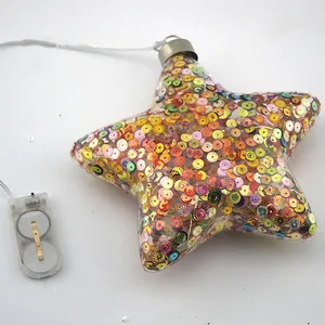 The product is made of glass and is adorned with sequins, giving it a festive and sparkling appearance. The LED lights add a warm glow to the design.