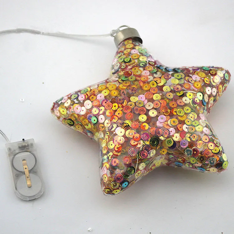 The product is made of glass and is adorned with sequins, giving it a festive and sparkling appearance. The LED lights add a warm glow to the design.