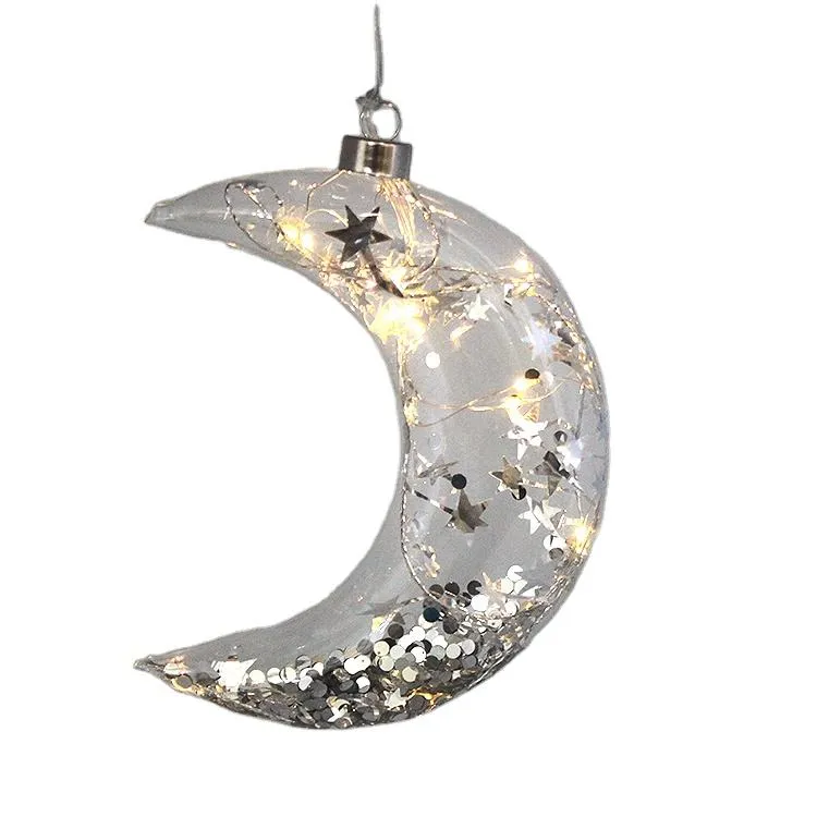 This product is a moon shaped glass Christmas ornament with a diameter of 12cm, and the material is clear glass. It is filled with silver stars and LED lights, perfect for holiday, wedding, party, and home decoration.