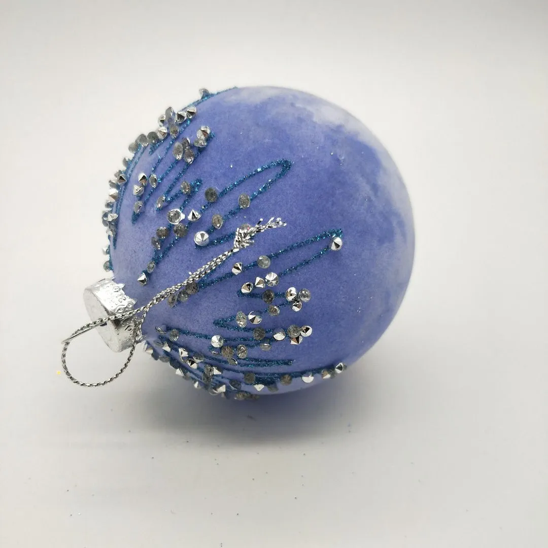 This product is made from high-quality blown glass and is covered in a soft velvet flocking, making it a beautiful and luxurious addition to any Christmas tree.