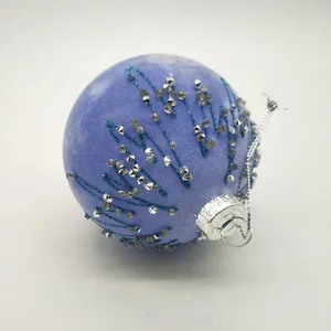 This product is decorated with silver glitter and blue paint, which are applied by hand. This gives each ornament a unique and handmade look.
