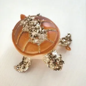 This product features a beautiful hand-painted design. The intricate details of the sea turtle are brought to life with vibrant colors and shimmering glitter.