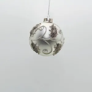 The green glitter leaves and silver detailing on these Christmas ornaments are hand-painted, creating a beautiful and intricate design.