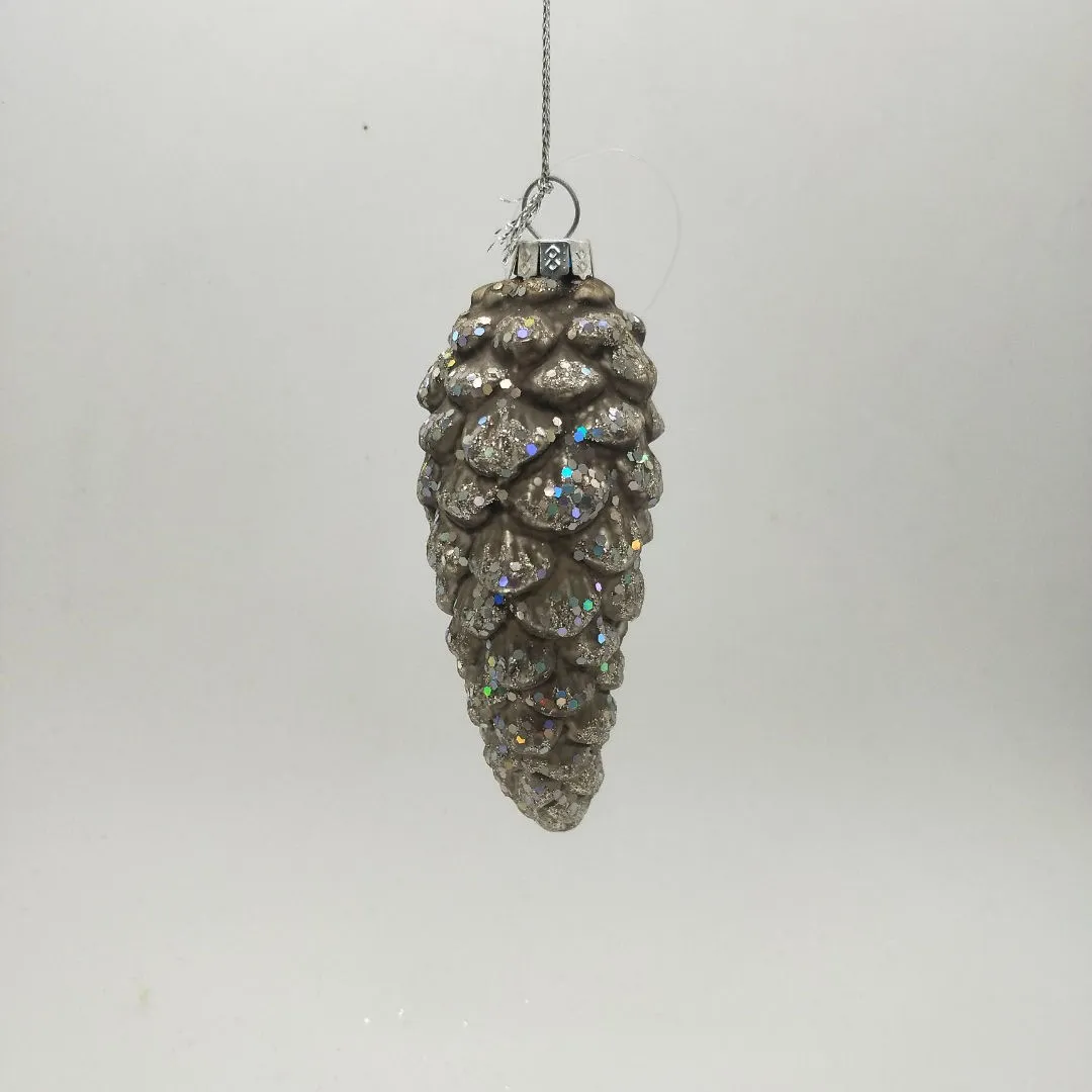 This product is a glass Christmas ornament shaped like a pinecone. It is covered in glitter for a sparkly effect. The pinecone ornament is perfect for adding a touch of Christmas cheer to your home.