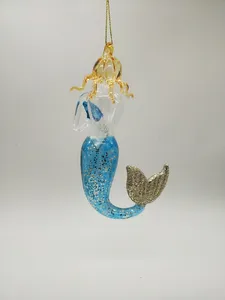 This product features a hand-blown glass mermaid ornament with a blue and gold design. It is perfect for Christmas tree decorations and adds a touch of whimsy to any holiday decor.