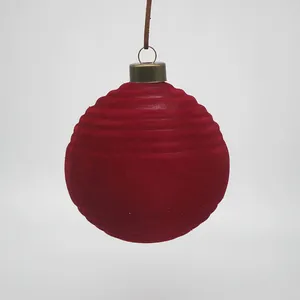 This Christmas glass ball ornament is made by blowing glass into a mold, which gives it a beautiful, round shape. The ornament is then carefully decorated with a layer of red velvet.